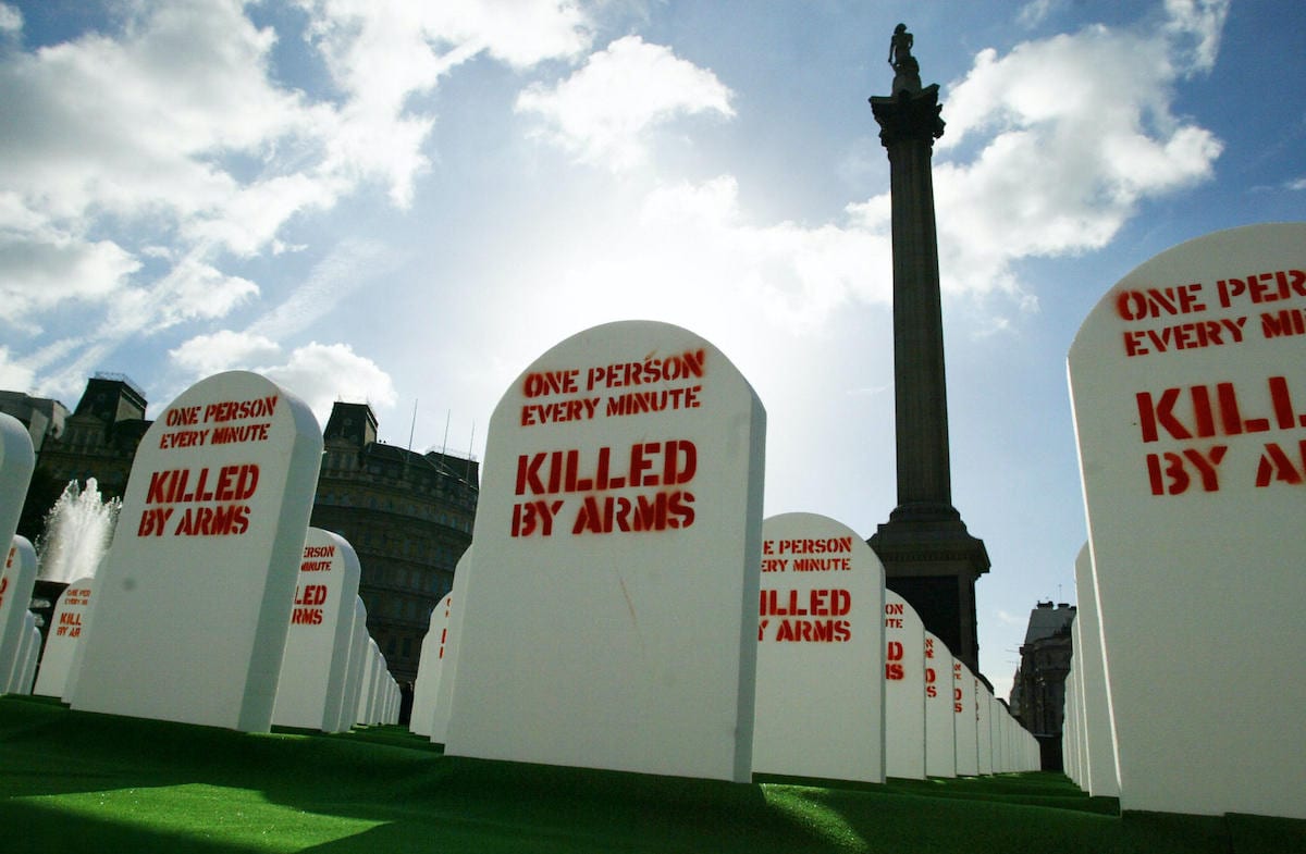 Mock grave stones lie in a life-sized graveyard set up in Trafalgar Square, central London, 09 October 2003 by Amnesty International and the British humanitarian group Oxfam to represent the more than half a million people on average killed with conventional, light weapons every year. [JIM WATSON/AFP via Getty Images]