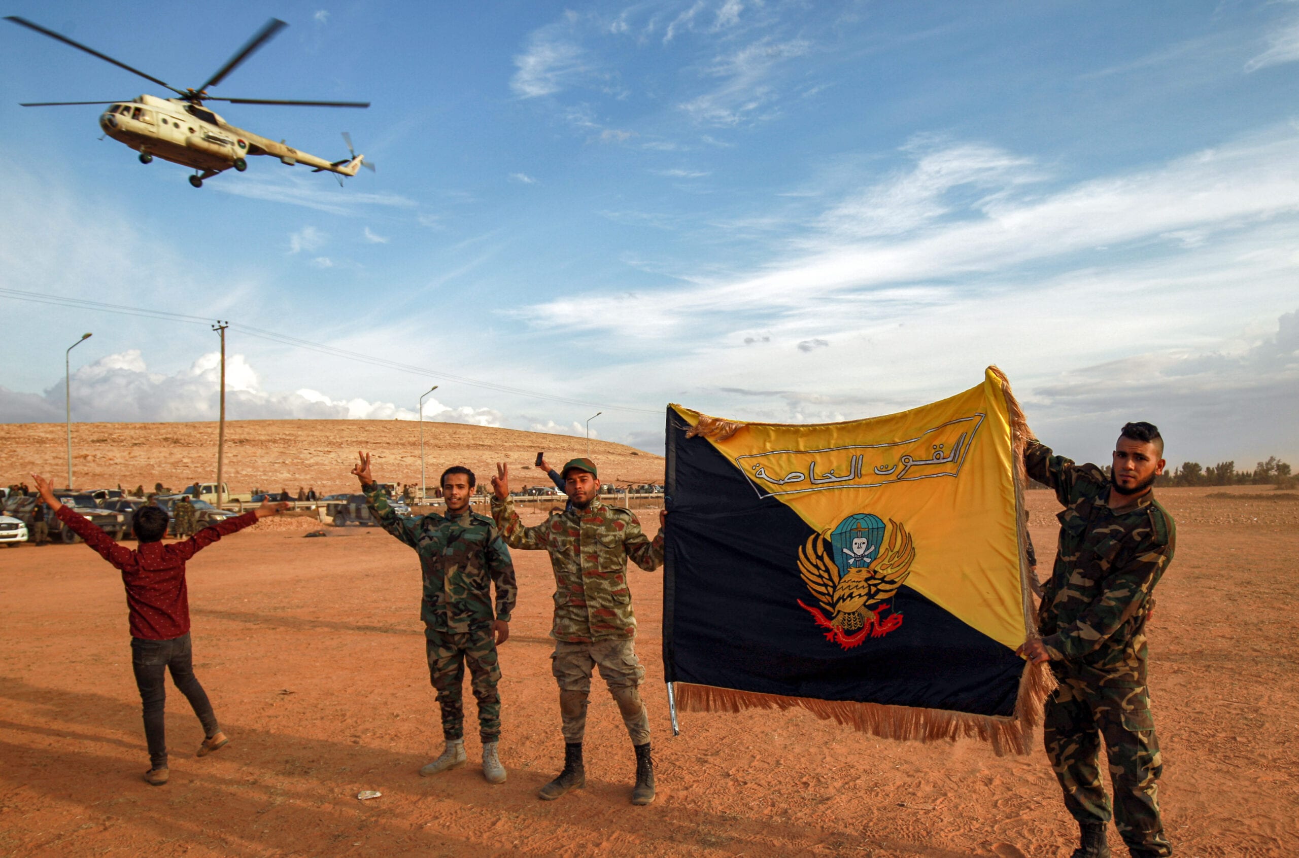 Members of the the "Saiqa" (Special Forces) of the self-proclaimed Libyan National Army (LNA), loyal to eastern strongman Khalifa Haftar, hold up their group's flag on November 6, 2020 [ABDULLAH DOMA/AFP via Getty Images]