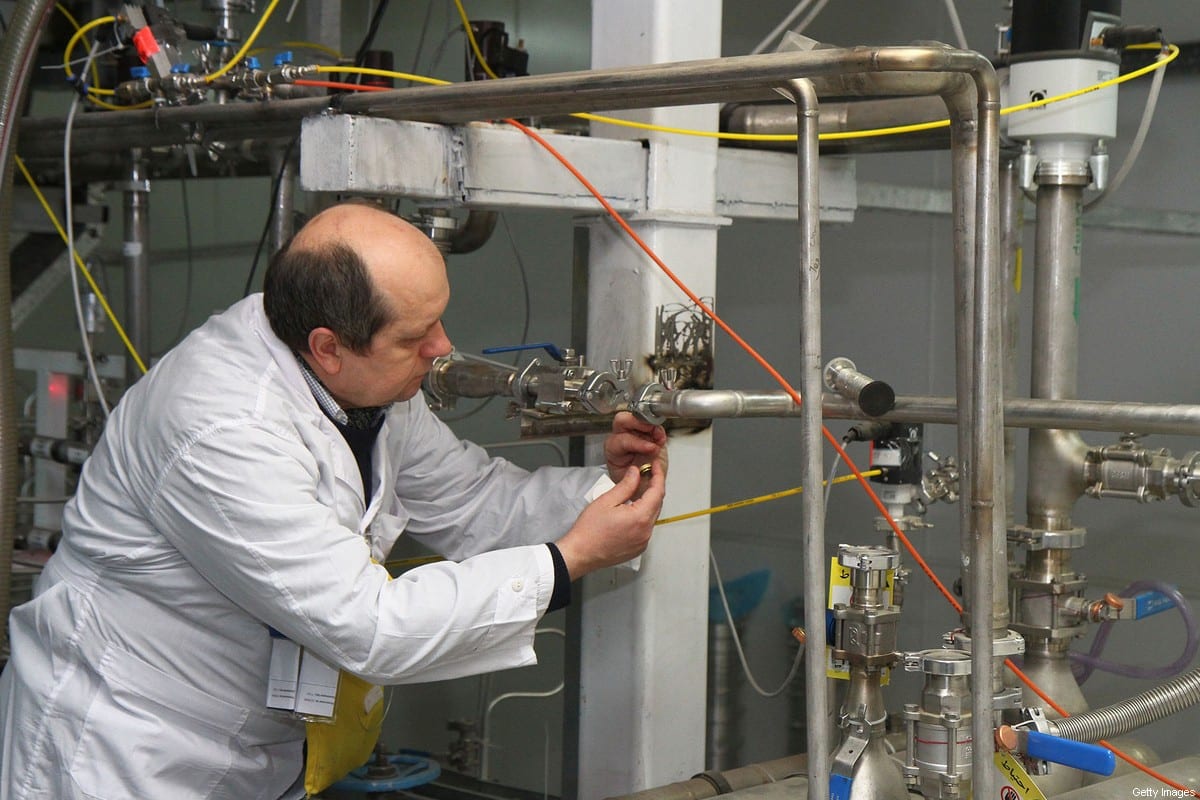 An unidentified International Atomic Energy Agency (IAEA) inspector disconnects the connections between the twin cascades for 20 percent uranium production at nuclear research centre of Natanz, some 300 kilometres south of Tehran on 20 January, 2014 [KAZEM GHANE/IRNA/AFP via Getty Images]