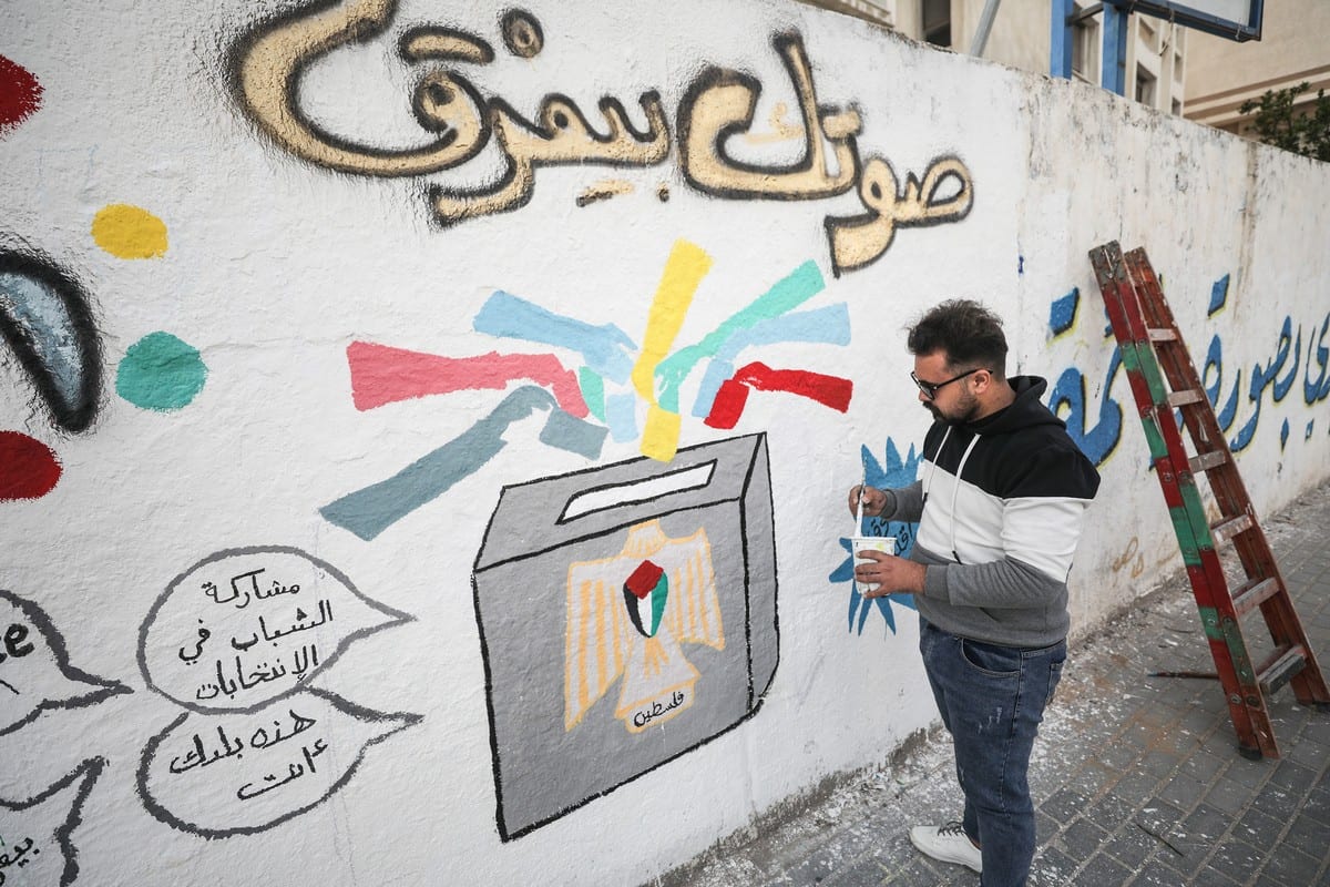 Palestinian artist paints an election related graffiti on a wall ahead of elections for the Palestinian Legislative Council in Gaza City, Gaza on 24 March 2021 [Mustafa Hassona/Anadolu Agency]