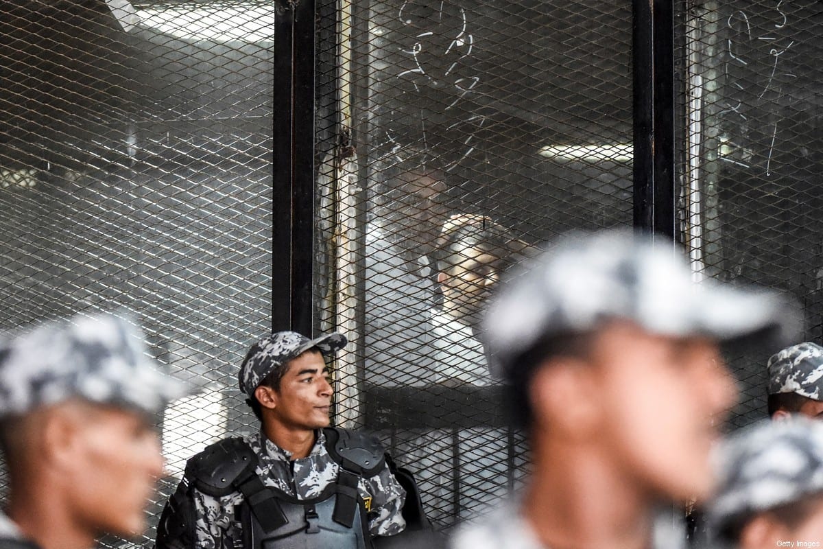 Egyptian photojournalist Mahmoud Abdel Shakour Abouzied (C), also known as Shawkan, is seen inside a soundproof glass dock during his trial in the capital Cairo on July 28, 2018. [Photo credit should read KHALED DESOUKI/AFP via Getty Images]