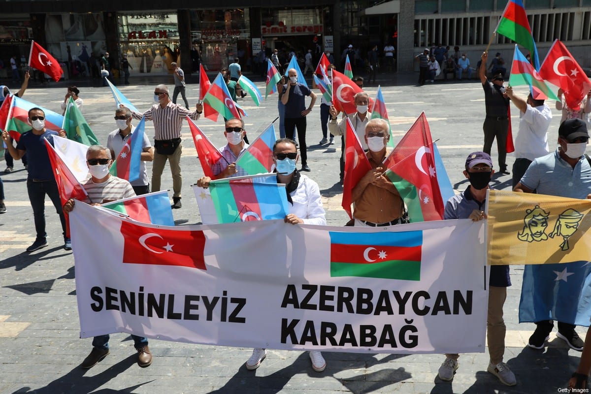Activists hold flags of Turkey and Azerbaijan as they gather in Ankara, on 8 August 2020 [ADEM ALTAN/AFP/Getty Images]