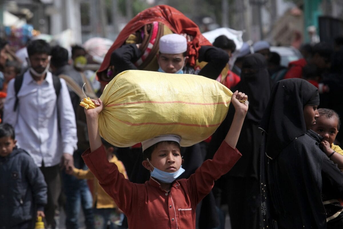 Rohingya refugees carry their belongings as they leave a Rohingya refugee camp in Jammu on March 7, 2021. (Photo by Rakesh BAKSHI / AFP) (Photo by RAKESH BAKSHI/AFP via Getty Images)