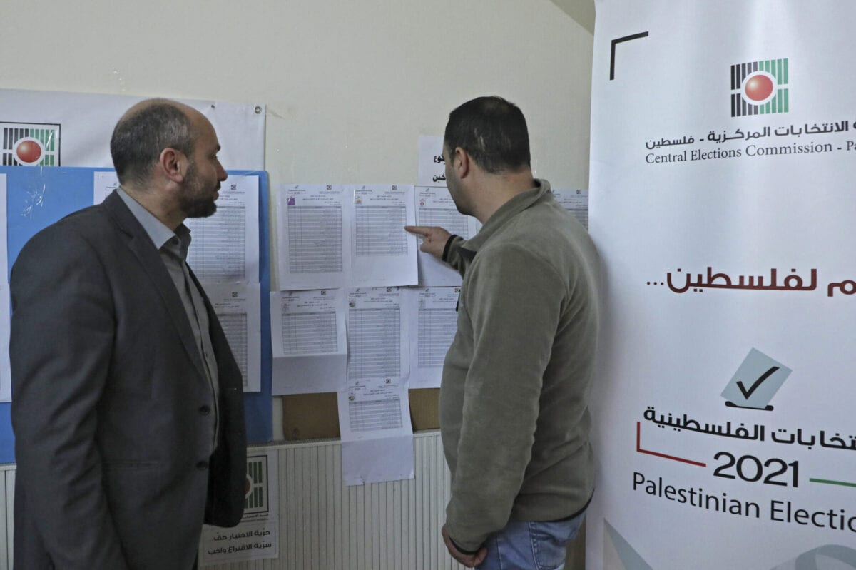 Employees of the Palestinian Central Elections Commission display electoral lists ahead of the upcoming general elections, at the commission's district offices in the city of Hebron in the Israeli-occupied West Bank, on April 6, 2021 [HAZEM BADER/AFP via Getty Images]