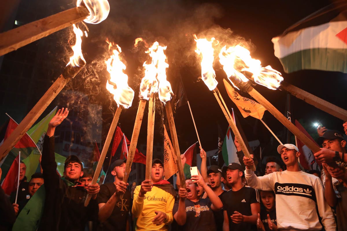 Palestinians light torches during a protest against attacks by Israeli police with tear gas, rubber bullets and stun grenades on Palestinians at Masjid al-Aqsa, in Nablus, West Bank on May 11, 2021 [Mamoun Wazwaz/Anadolu Agency]