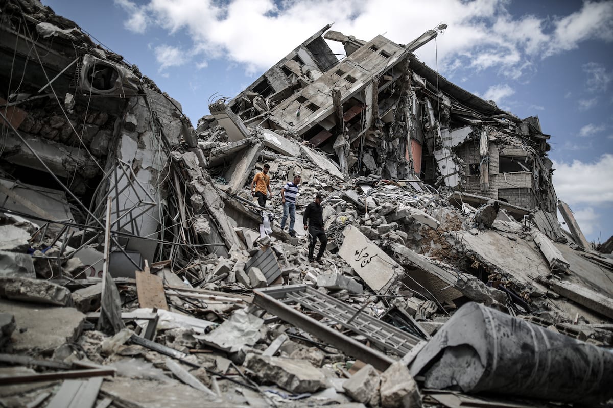 Palestinians clear debris from their shops, which were damaged in Israeli attacks, in Gaza on 22 May 2021 [Ali Jadallah/Anadolu Agency]