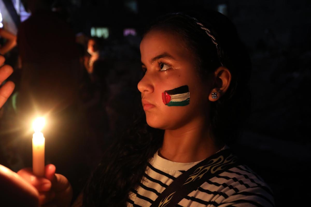 Palestinian children light candles in memory of Abu Hattab family killed in the Israeli air strikes on Gaza, on 23 May 2021 [Ashraf Amra/Anadolu Agency]