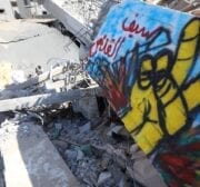 Palestinian artists draw murals on the ruins of Al-Shurouk Tower in Gaza to highlight the people’s steadfastness on 25 May 2021 [Mohammed Asad/Middle East Monitor]
