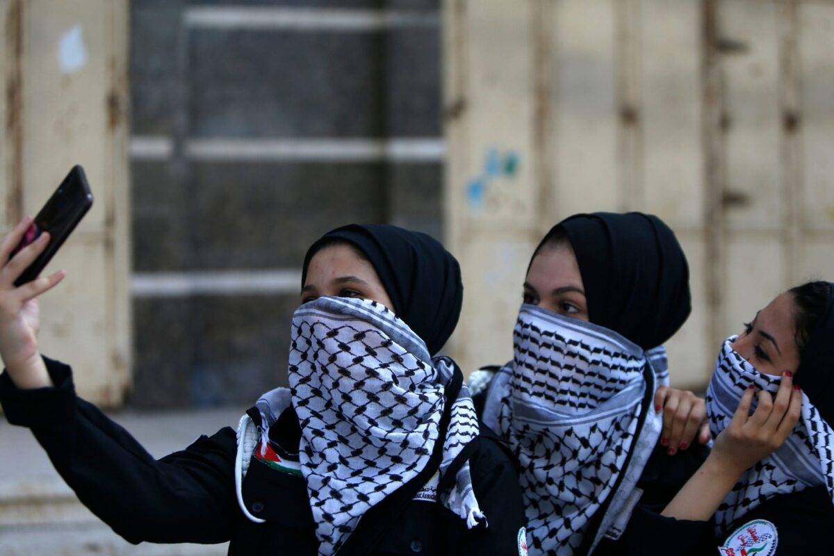 Palestinian youths, using the traditional keffiyeh scarves as masks due to COVID-19 in Gaza City on 22 June 2020 [MOHAMMED ABED/AFP/Getty Images]