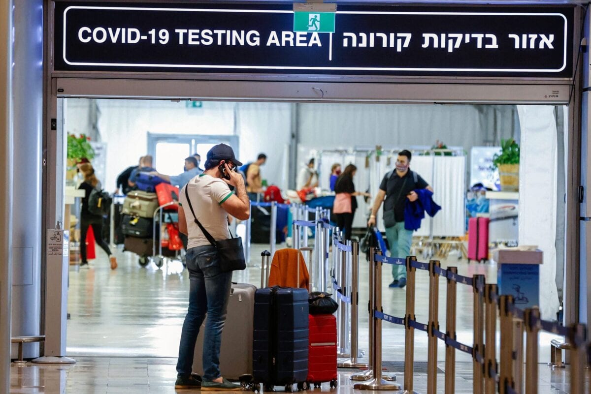 Vaccinated tourists wearing masks for COVID-19 protection arrive to Israel's Ben Gurion Airport near Tel Aviv on May 23, 2021, after a partial re-opening of the border to inoculated tourists from 14 countries [JACK GUEZ/AFP via Getty Images]