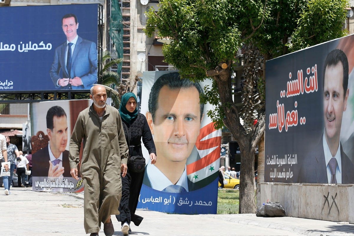 People walk past billboards depicting Syrian President Bashar Al-Assad in Damascus, on 24 May 2021 [LOUAI BESHARA/AFP/Getty Images]