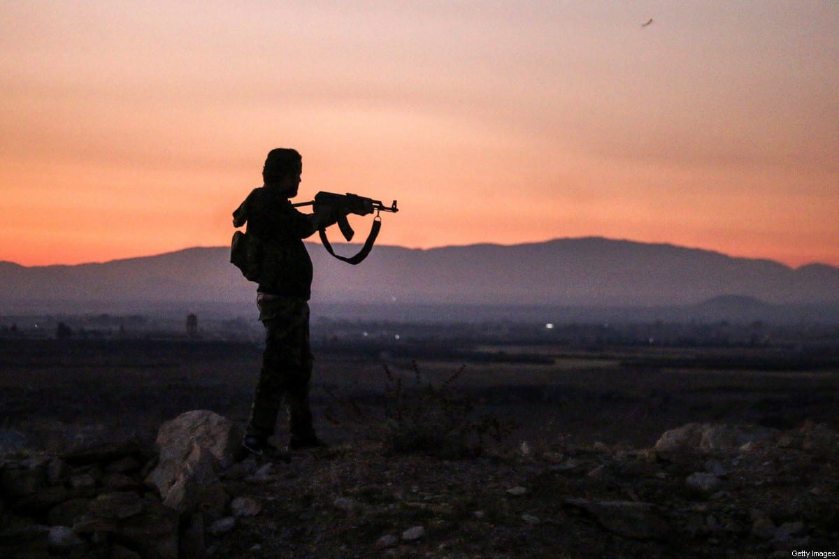 TOPSHOT - A Syrian rebel fighter aims his Kalashnikov assault rifle as he stands near the frontline against government forces west of the embattled southern city of Daraa on July 3, 2018. (Photo by Mohamad ABAZEED / AFP) (Photo credit should read MOHAMAD ABAZEED/AFP via Getty Images)