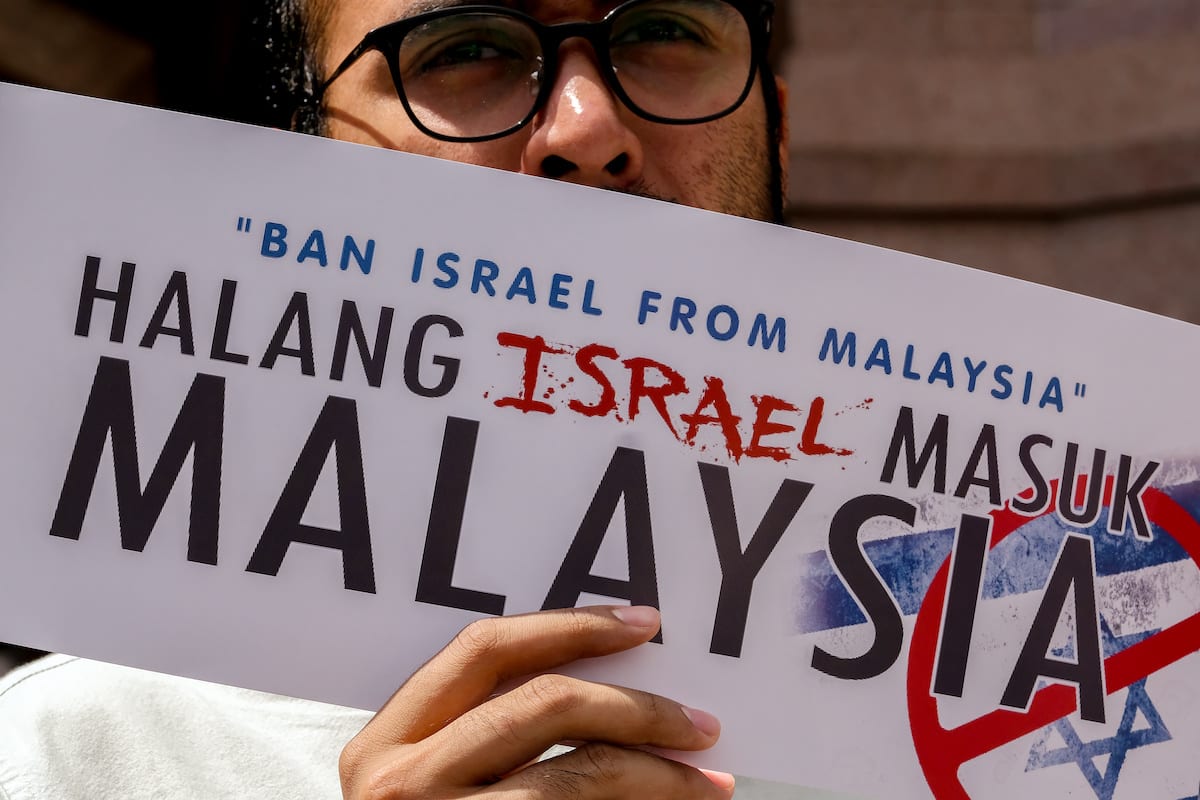 A protestor holds a poster outside the Putra mosque during demonstrations against Israel to enter Malaysia as they support the Malaysia prime minister statement on 1 February 2019 in Putrajaya outside Kuala Lumpur, Malaysia. [Mohd Samsul Mohd Said/Getty Images]