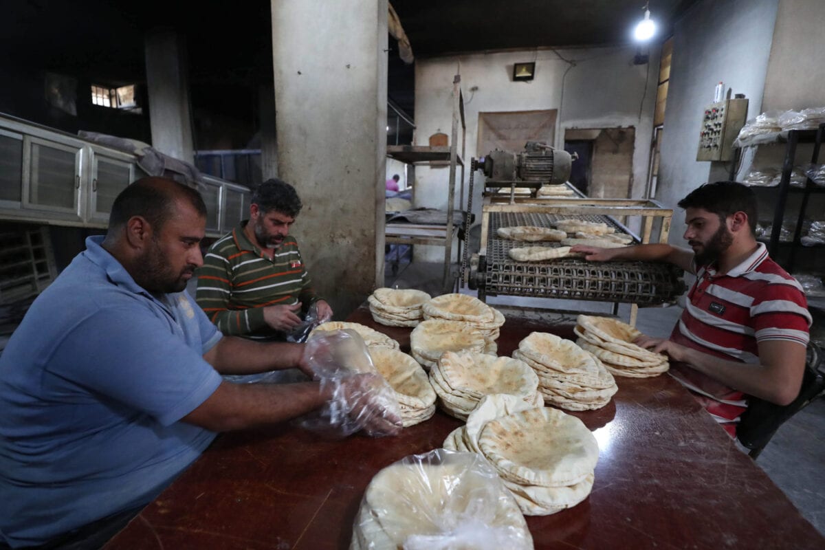 Syrians pack bread at a bakery in the town of Binnish in the country's northwestern Idlib province on June 9, 2020 [OMAR HAJ KADOUR/AFP via Getty Images]