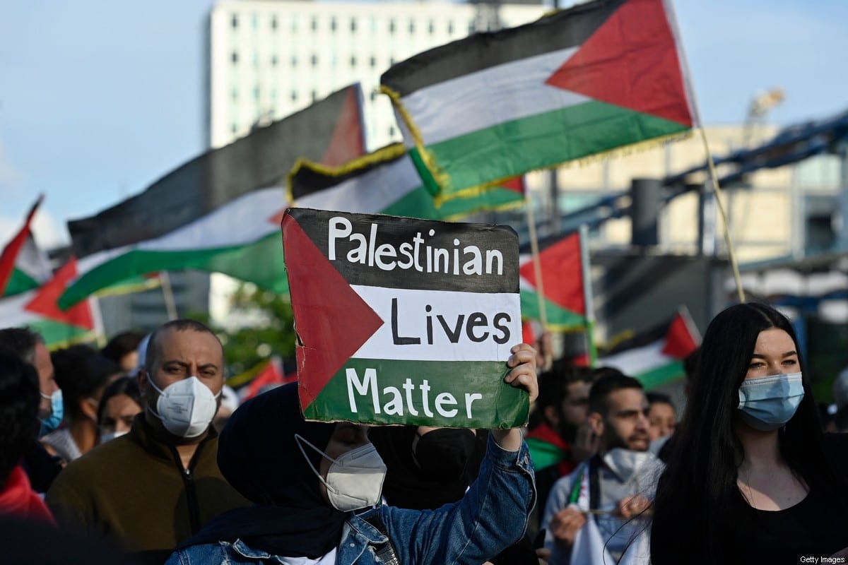 A demonstrator displays a placard reading: "Palestinian Lives Matter" during a pro-Palestinian protest in Berlin on 19 May 2021 [JOHN MACDOUGALL/AFP/ Getty Images]