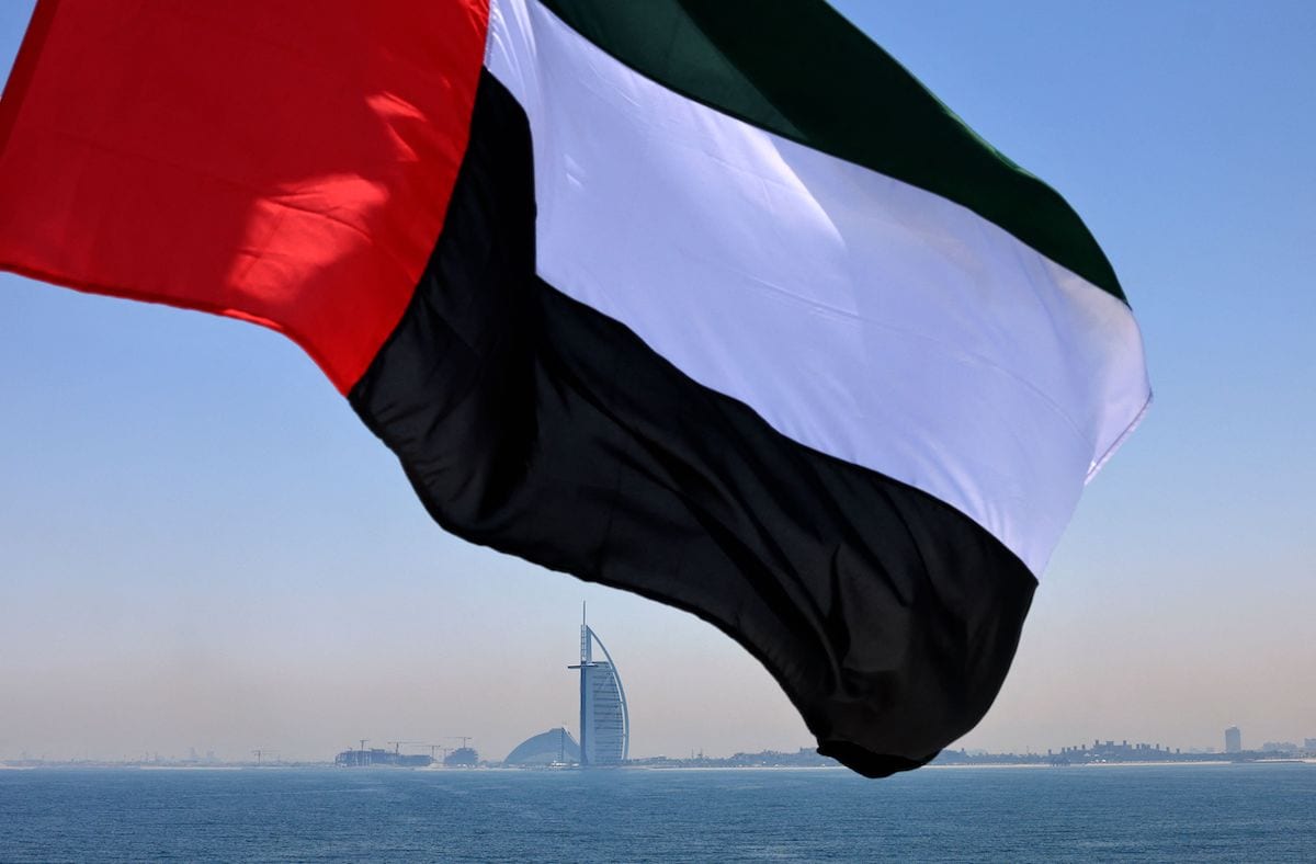 An Emirati flag fluttering above Dubai's marina with the Burj Al Arab landmark hotel (C) in the background, 3 June 2021 [KARIM SAHIB/AFP via Getty Images]