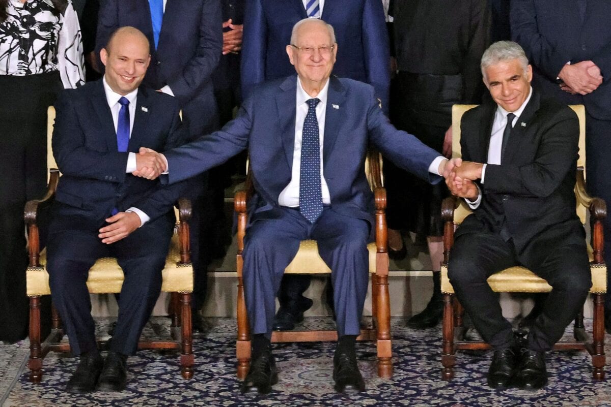 Outgoing Israeli President Reuvin Rivlin (C) is flanked by Prime Minister Naftali Bennett (L) and alternate Prime Minister and Foreign Minister Yair Lapid during a photo with the new coalition government, at the President's residence in Jerusalem, on June 14, 2021 [EMMANUEL DUNAND/AFP via Getty Images]