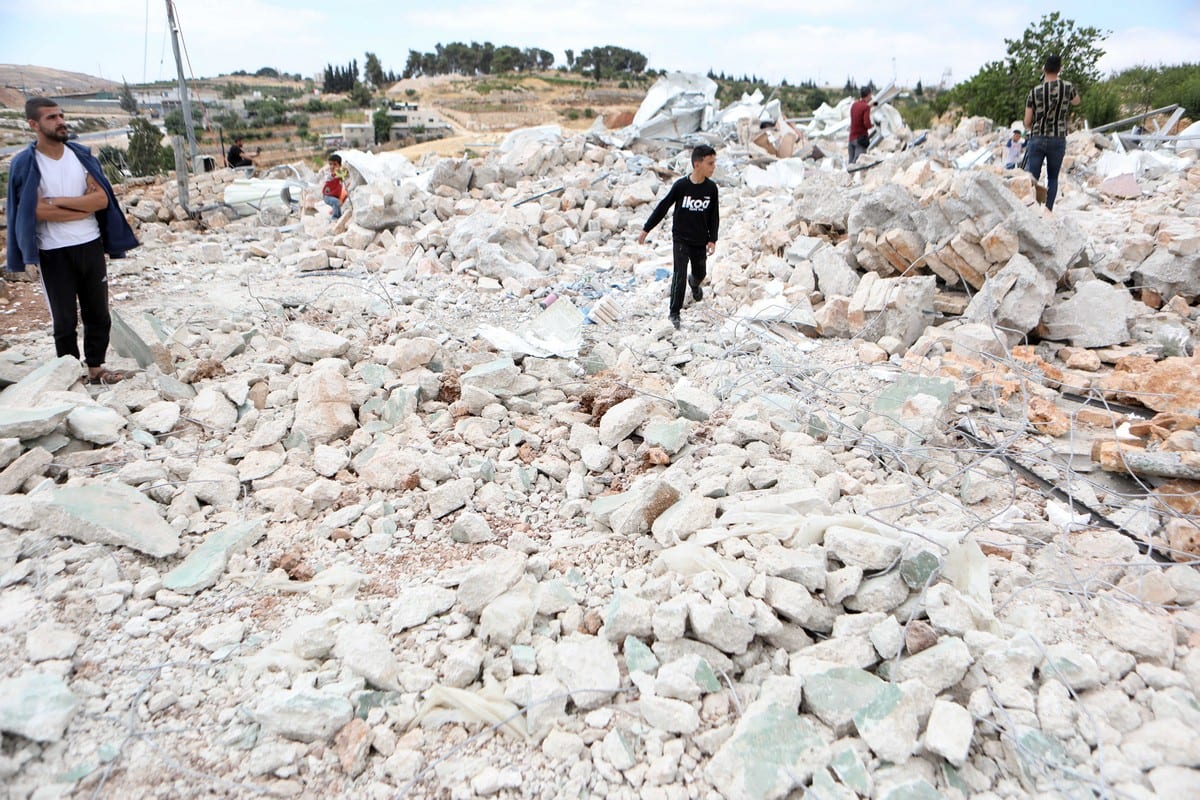 Palestinians collect their usable wares from ruins after Israeli forces demolished their house in the West Bank on 17 June 2021 [Mamoun Wazwaz/Anadolu Agency]