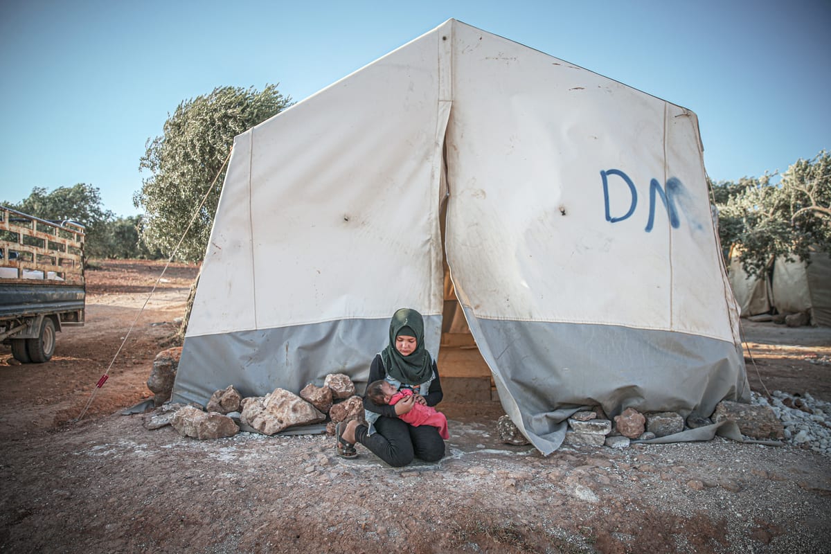 A view of civilians taking shelter in camps along the frontier between Turkey and northwestern Syria as they call for keeping the Bab al-Hawa border crossing open for aid transfer, which is essential for them to survive, in Idlib, Syria on July 2, 2021 [Muhammed Said/Anadolu Agency]