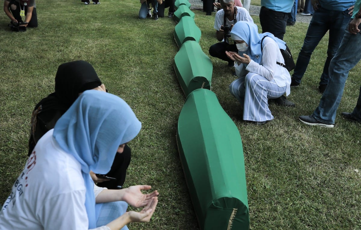 Relatives pray next to the coffins of 19 victims of Srebrenica Genocide ahead of buried at Potocari Memorial Cemetery, on the 26th anniversary of the 1995 genocide in Srebrenica, Bosnia and Herzegovina on July 10, 2021 [Samır Jordamovıc - Anadolu Agency]