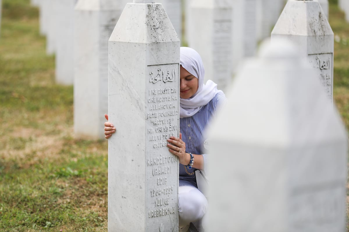 SREBRENICA, BOSNIA AND HERZEGOVINA - JULY 11: A woman mourns near a gravestone as funeral ceremony for 19 victims of the Srebrenica Genocide, whose identities have been detected, held at Potocari cemetery in Srebrenica, Bosnia and Herzegovina on July 11, 2021. ( Elman Omic - Anadolu Agency )
