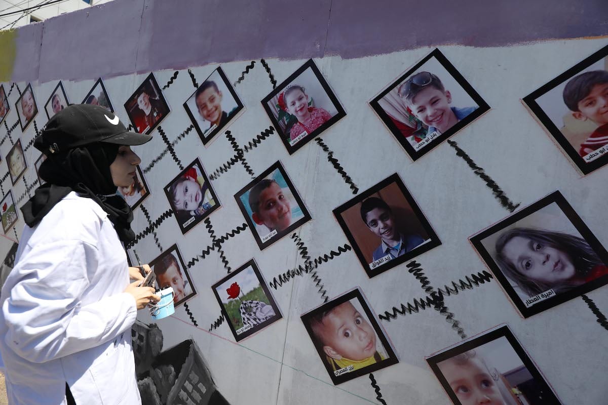 Pictures of Palestinian children killed in the Israeli attack on Gaza in May 2021 are placed outside the UNDP office on 13 July 2021 [Mohammed Asad/Middle East Monitor]