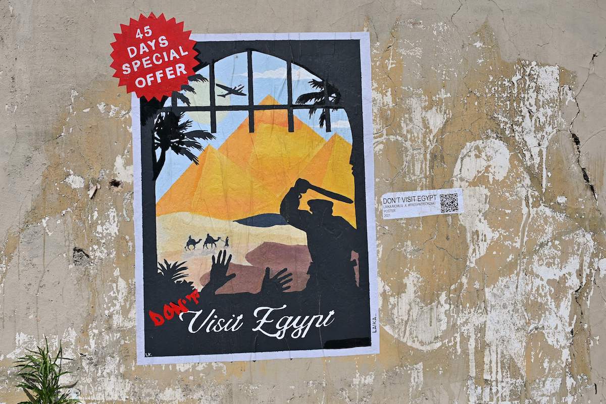 A poster by Italian street artist Laika, entitled "Don't visit Egypt", is pictured on a wall near the Egyptian embassy on June 16, 2021 in Rome in protest against the recent extension of the detention in Egypt of a 29-year-old Egyptian student Patrick Zaki. [ALBERTO PIZZOLI/AFP via Getty Images]