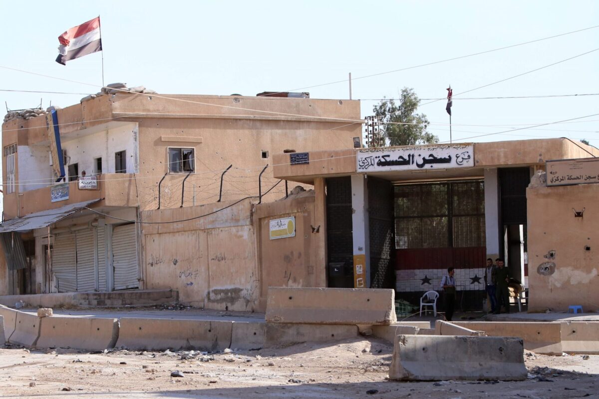 Members of the Syrian regime forces stand at the entrance of a detention centre in the northeastern Syrian city of Hasakeh's Ghweran neighborhood, on July 13, 2015 [YOUSSEF KARWASHAN/AFP via Getty Images]