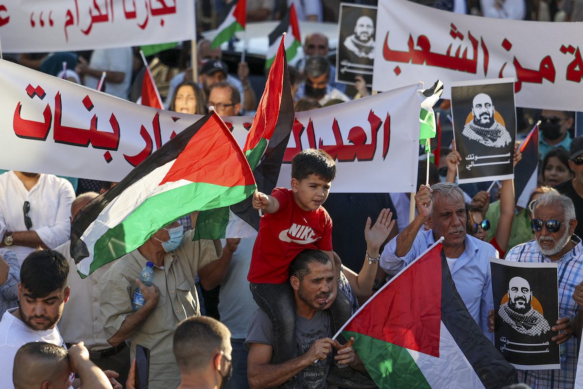 Palestinian protesters rally in Ramallah city in the occupied West Bank on July 17, 2021, denouncing the Palestinian Authority (PA) in the aftermath of the death of activist Nizar Banat while in the custody of PA security forces. [ABBAS MOMANI/AFP via Getty Images]