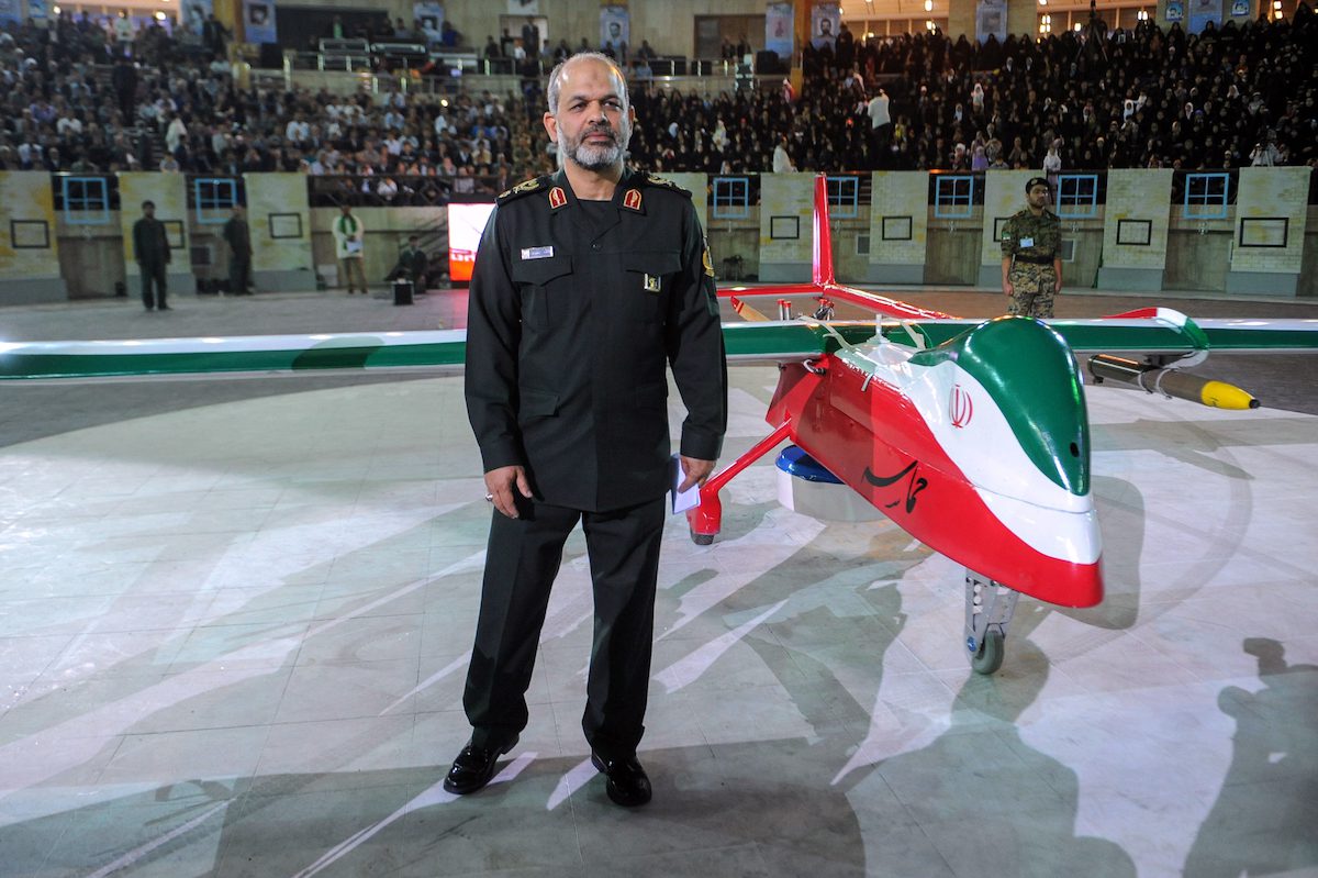 Iranian Defence Minister Ahmad Vahidi stands next to the new Iranian made drone "Epic" during a ceremony in Tehran on 9 May 2013. [HEMMAT KHAHI/AFP via Getty Images]