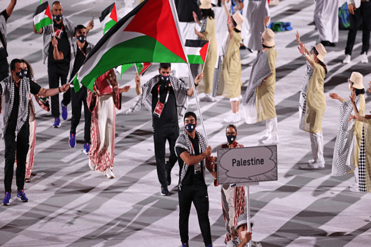 Team Palestine flagbearers Dania Nour and Mohammed K H Hamada carry the Palestinian flag during the 2020 Tokyo Summer Olympic Games opening ceremony at the Olympic Stadium in Tokyo, Japan [Stephen McCarthy/Sportsfile via Getty Images]