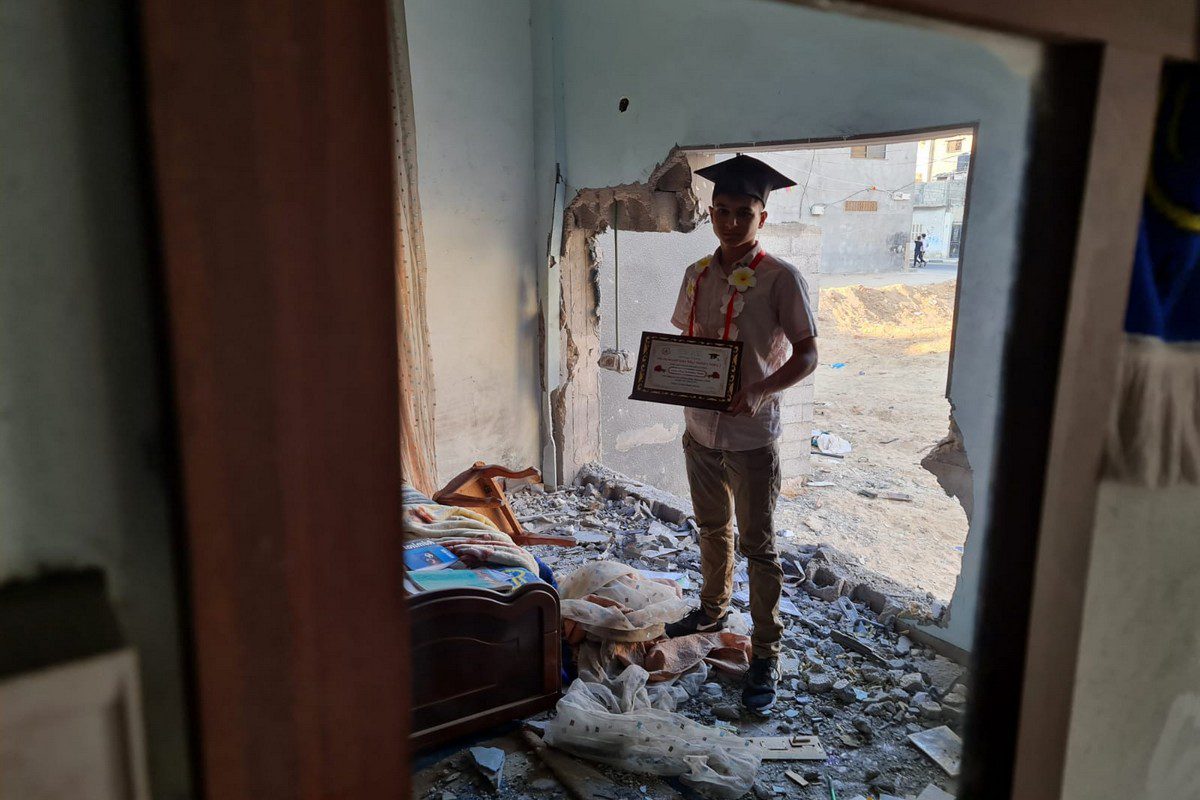 Palestinian student Yehya Al-Saqqa from Khan Yunis stands in his destroyed bedroom after he attained 94% in the Tawjihi exams. Al-Saqqa's home was partially destroyed by the Israeli bombing campaign on Gaz in May 2021, just one month before he sat the exams.