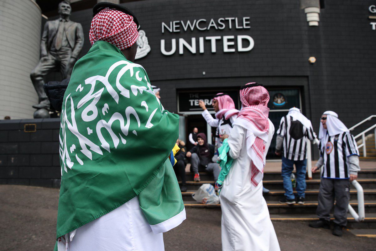 A fan of Newcastle United can be seen wearing the traditional Saudi head dress and draped in a Saudi Arabia flag head of the Premier League match between Newcastle United and Tottenham Hotspur in London, UK. [Robbie Jay Barratt /AMA/Getty Images]