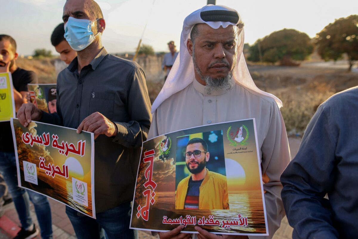 Arab-Israelis and Israeli left-wing activists hold placards during a demonstration calling for the release of Palestinian administrative detainees including Miqdad al-Qawasmeh on October 16, 2021 [AHMAD GHARABLI/AFP via Getty Images]