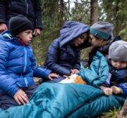 The Massini family from Syria, father Muhammad (L), mother Alaa (C) and their two sons are comforted by activist Pamela (2nd,R) from the Grupa Granica (Border Group) while awaiting transport in the forest near the east Polish town of Kleszczele , October 22, 2021. - Thousands of migrants, mostly from the Middle East have crossed or tried to cross from Belarus since the summer. The EU believes the Belarusian regime is deliberately sending the migrants over in retaliation against EU sanctions. (Photo by Wojtek RADWANSKI / AFP) (Photo by WOJTEK RADWANSKI/AFP via Getty Images)