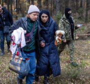 Alaa Massini (C-R), refugee from Syria, speaks with Klara (C-L), an activist from the Grupa Granica (Border Group), as they walk with border guard officers in the woods near Kleszczele, Poland, on October 22, 2021. - Thousands of migrants, mostly from the Middle East have crossed or tried to cross from Belarus since the summer. The EU believes the Belarusian regime is deliberately sending the migrants over in retaliation against EU sanctions. - TO GO WITH AFP STORY by Anna Maria JAKUBEK (Photo by Wojtek RADWANSKI / AFP) / TO GO WITH AFP STORY by Anna Maria JAKUBEK (Photo by WOJTEK RADWANSKI/AFP via Getty Images)