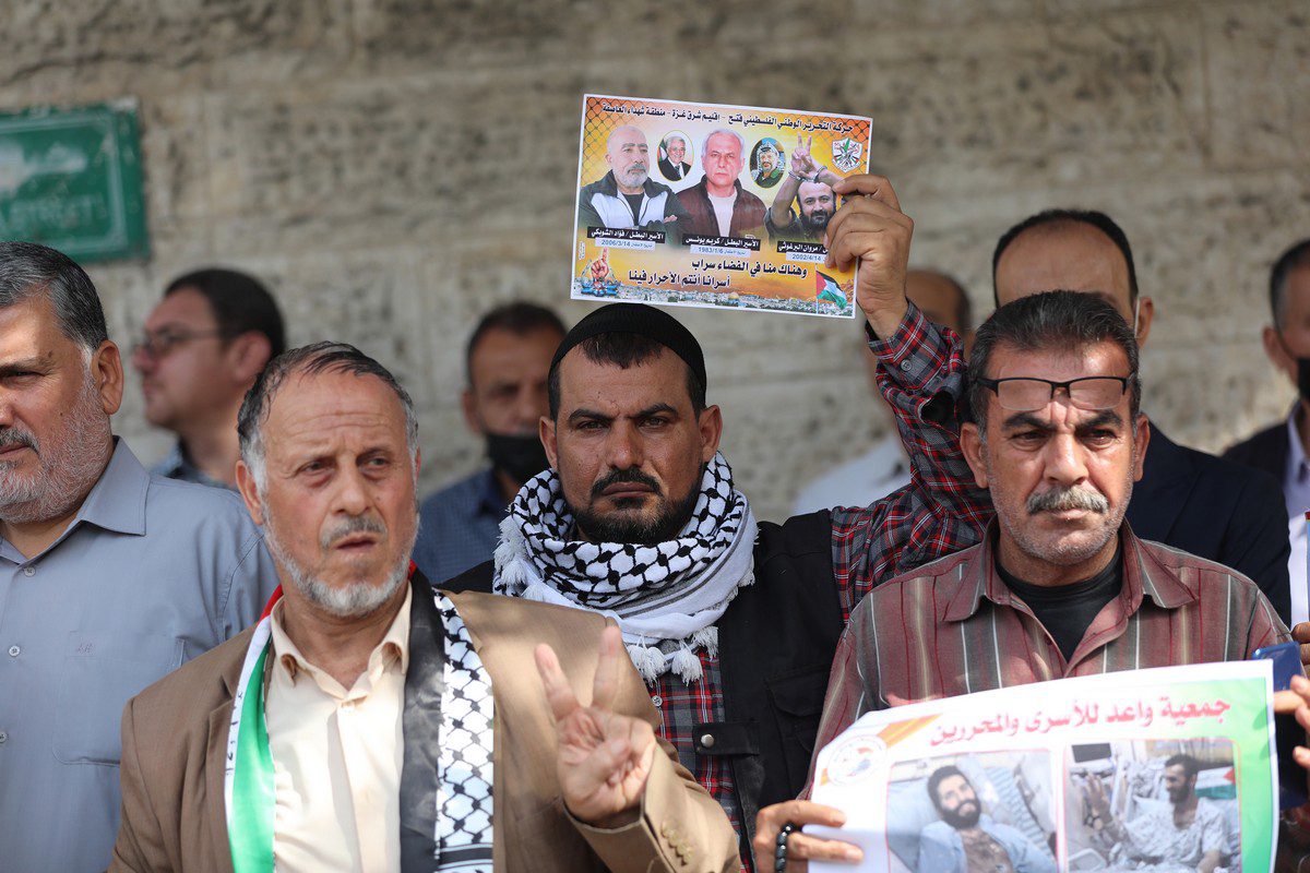 People hold banners during a protest against Israel's administrative detention and a demonstration in support of Palestinian prisoners on hunger strike in Israeli jails outside the International Committee of the Red Cross building in Gaza City, Gaza on November 01, 2021. [Mustafa Hassona - Anadolu Agency]