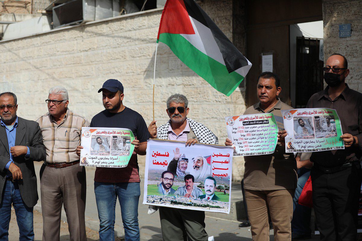People hold banners during a protest against Israel's administrative detention and a demonstration in support of Palestinian prisoners on hunger strike in Israeli jails outside the International Committee of the Red Cross building in Gaza City, Gaza on November 01, 2021. [Mustafa Hassona - Anadolu Agency]