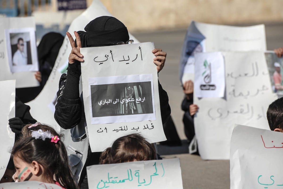 Syrian women stage a protest in demand of the release of detainees prisoned by Assad Regime in Idlib, Syria On 12 November 2021 [İzzettin Kasim/Anadolu Agency]