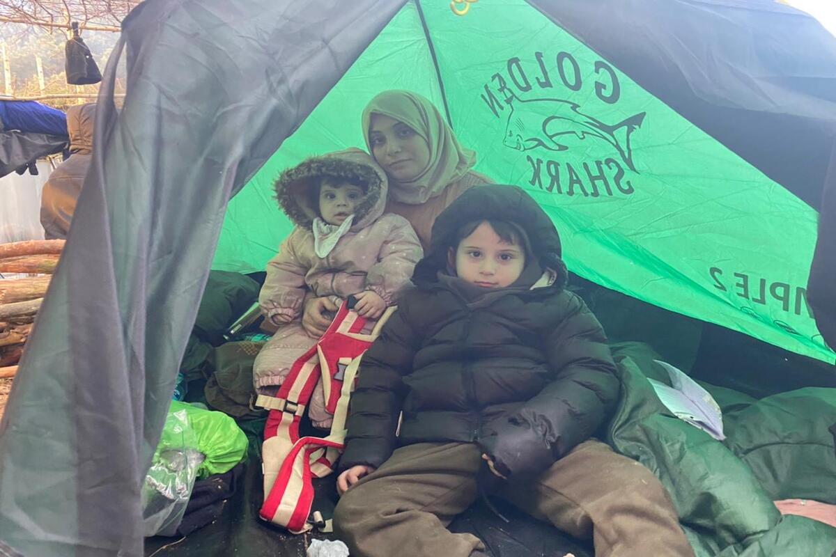 BELARUS - NOVEMBER 13: Iraqi migrant mother is seen with her children and she wants to receive help for her child with illness as she and other Iraqi migrants continue to wait at the Polish-Belarusian border during cold weather on November 13, 2021 in Belarus. Thousands of irregular migrants including Iraqis are facing desperate conditions as they continue waiting at the Polish-Belarusian border, hoping to cross onto EU soil. After crossing the Bruzgi border point in Grodno, Belarus on Monday, the immigrants – most of them from Iraq – came to the Polish border to spend Tuesday night. Nearly 2,000 immigrants, including many women and children, stayed in tents they set up in front of the border fences in the forested area. ( Stringer - Anadolu Agency )