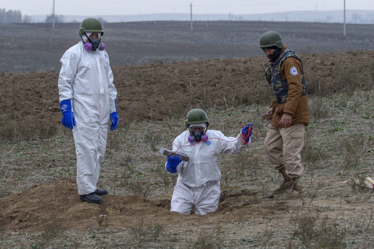 Azerbaijani sappers prepare an unexploded shell for an explosion outside the town of Fuzuli on November 18, 2020 [TOFIK BABAYEV/AFP via Getty Images]