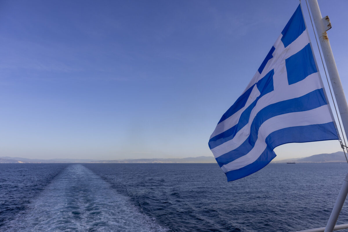 View of the Greek flag from ship leaving the port Tino island on April 14, 2021 in Tinos, Greece [Athanasios Gioumpasis/Getty Images]