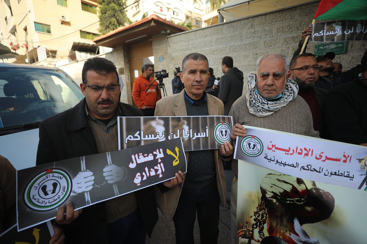 Palestinians holding banners gather to protest against the decision of Israel's "administrative detention" in front of the Red Crescent Building in Gaza City, Gaza on December 20, 2021 [Mustafa Hassona/Anadolu Agency]