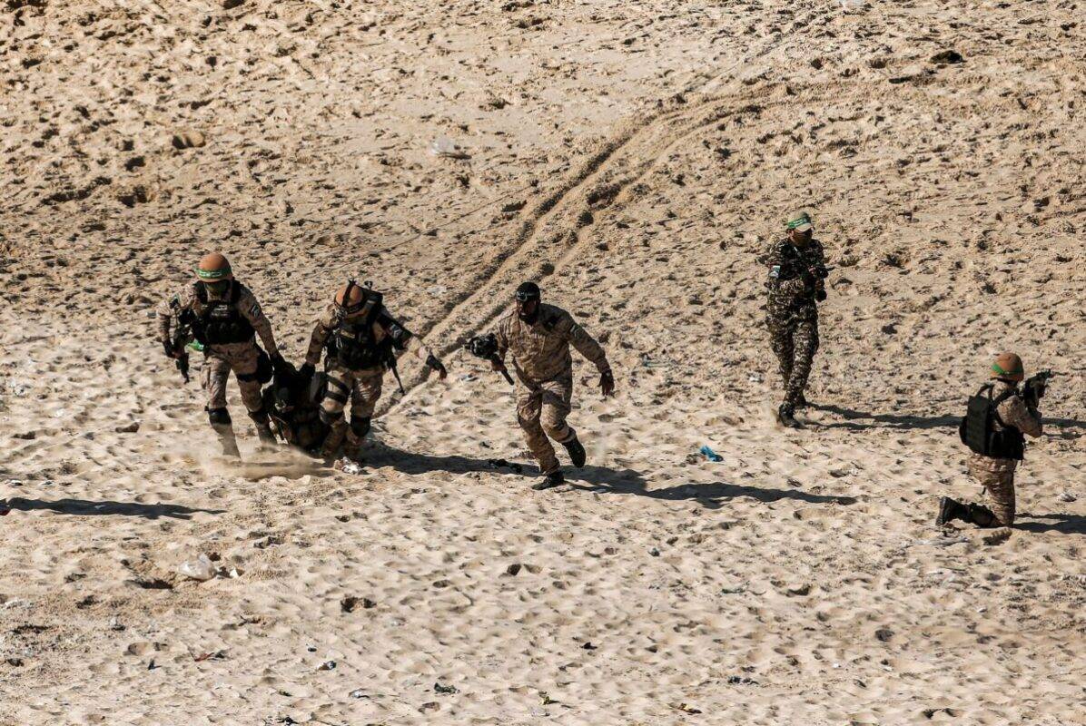 Armed fighters take part in a military drill by Hamas and other Palestinian armed factions on a beach in Gaza City on December 29, 2020 [MAHMUD HAMS/AFP via Getty Images]