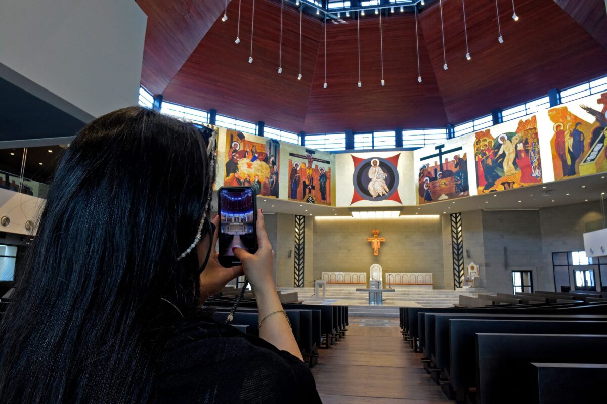A woman takes pictures of the Our Lady of Arabia Cathedral in Awali, south of the Bahraini capital Manama, on December 8, 2021. - The church, which cost more than 14.5 million US Dollars (BD 5.5) and can seat up to 2,300 people, is the largest Roman Catholic cathedral in the Arabian Peninsula. It will serve as the center of pastoral services in the whole Apostolic Vicariate of Northern Arabia which covers Bahrain, Kuwait, Qatar and Saudi Arabia. (Photo by Mazen Mahdi / AFP) (Photo by MAZEN MAHDI/AFP via Getty Images)
