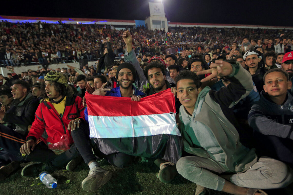 Yemeni fans gather at a stadium to watch on a screen the West Asian Junior Championships Cup football match between Yemen and Saudi Arabia, in the Huthi-held Yemeni capital Sanaa on December 13, 2021 [MOHAMMED HUWAIS/AFP via Getty Images]