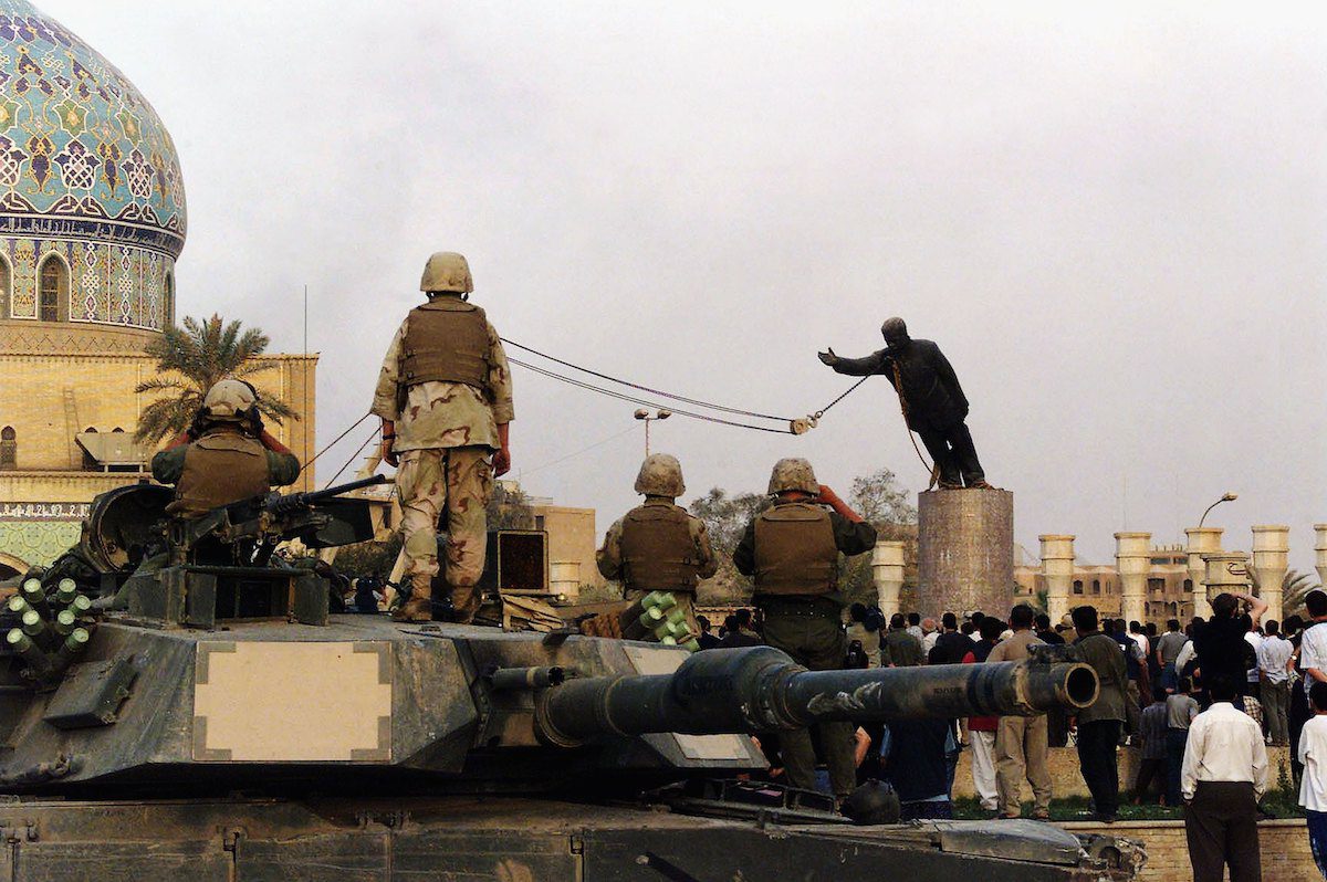 U.S marines and Iraqis are seen as the statue of Iraqi dictator Saddam Hussein is toppled at al-Fardous square in Baghdad, Iraq [Wathiq Khuzaie /Getty Image]