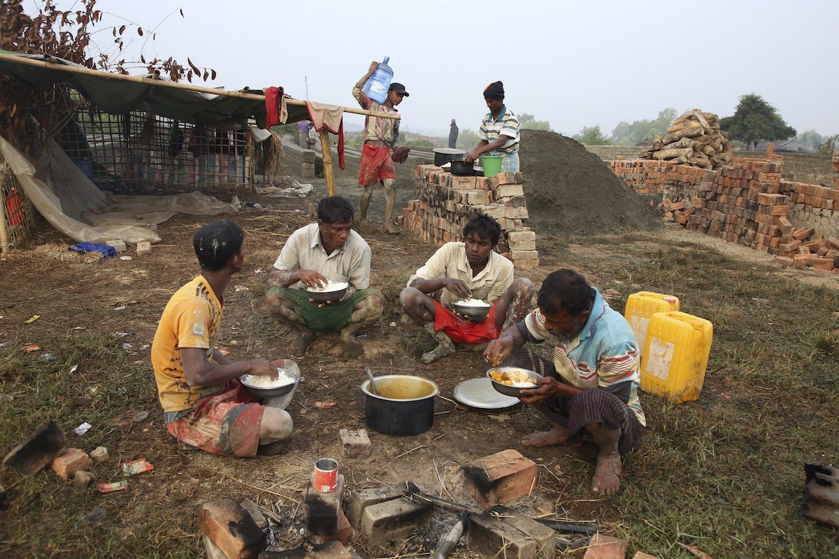 Rohingya laborers have lunch during their break as they work at a brick production workplace in a village on December 23, 2021, in Sittwe, Rakhine State, Myanmar [Aung Naing Soe/Anadolu Agency]