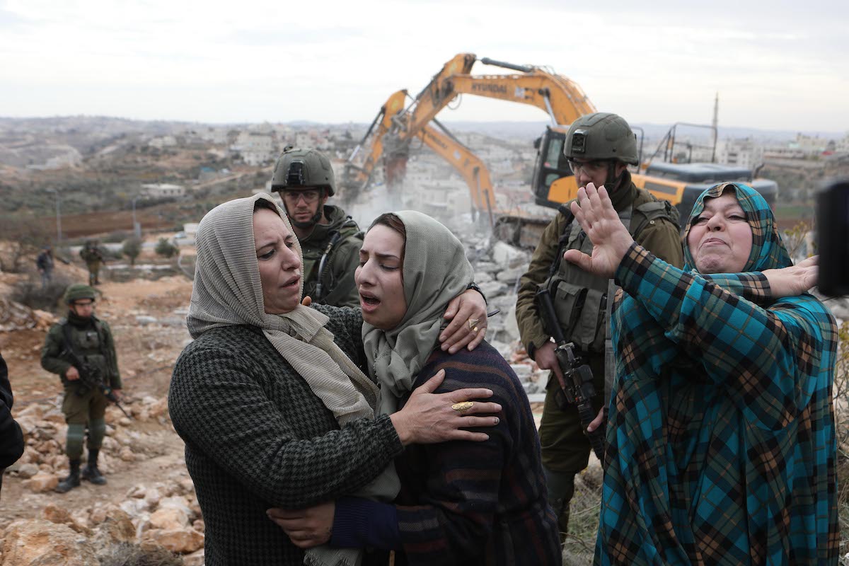 Palestinian residents react as their house, located in Area C, is demolished by Israeli forces allegedly for being "unlicensed", in Hebron, West Bank on December 28, 2021 [Mamoun Wazwaz/Anadolu Agency]