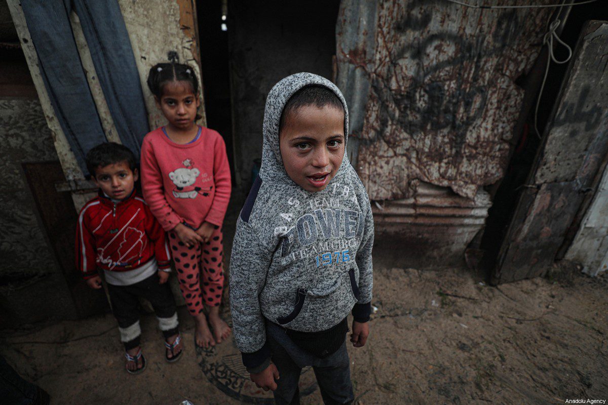Palestinian children are seen during cold weather of winter season at the makeshift house without windows and a door, in Ein al-Zeitun neighborhood, in Gaza City, Gaza on January 24, 2022 [Mustafa Hassona/ Anadolu Agency]